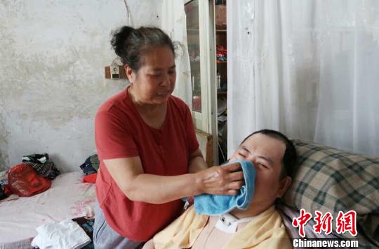 每次喂完食物后，梁青蘭都要仔細(xì)地幫兒子清理干凈。　尚明俠 攝