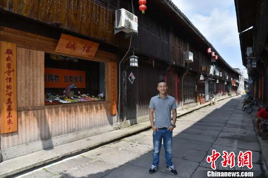 圖為:“誠(chéng)信小賣部”的店主王金偉 范宇斌 攝