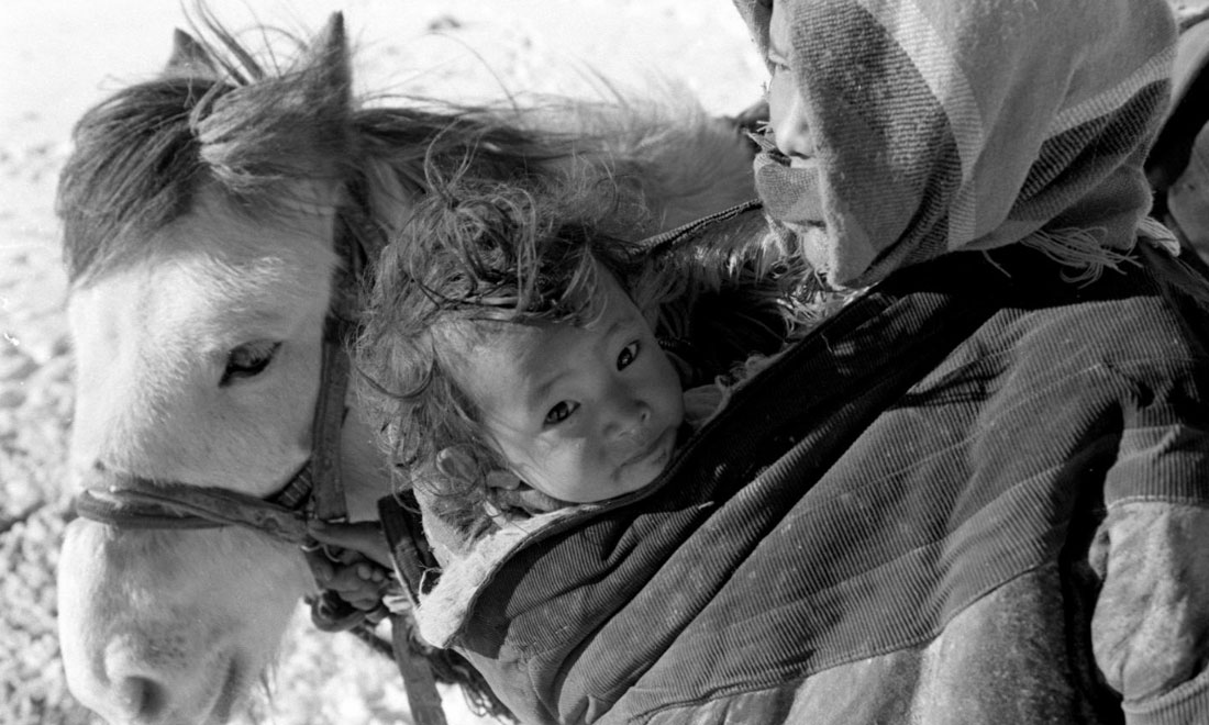 1990年3月，西藏當(dāng)雄縣納木湖鄉(xiāng)三村女牧民斯卓不畏嚴(yán)寒，懷抱幼子，準(zhǔn)備到遠(yuǎn)處放牧。新華社記者覺(jué)果攝