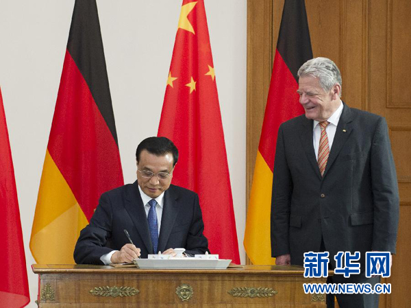 10月10日，國務(wù)院總理李克強在柏林會見德國總統(tǒng)高克。這是李克強總理在高克總統(tǒng)的陪同下在貴賓簿上簽字。 新華社記者 王曄 攝 