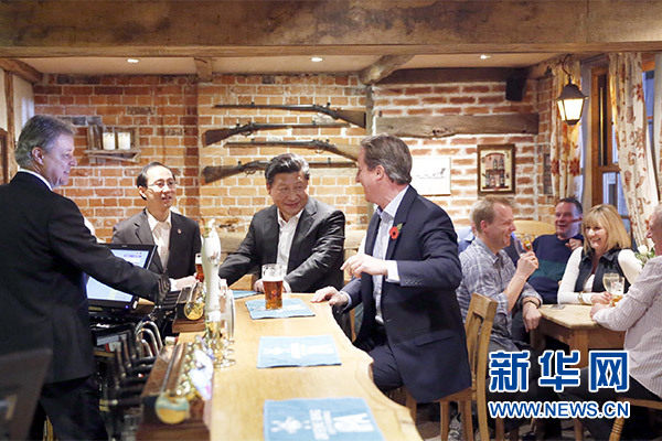 這是會晤結束后，習近平在卡梅倫陪同下乘車前往當地小鎮(zhèn)體驗酒吧文化。新華社記者 鞠鵬 攝